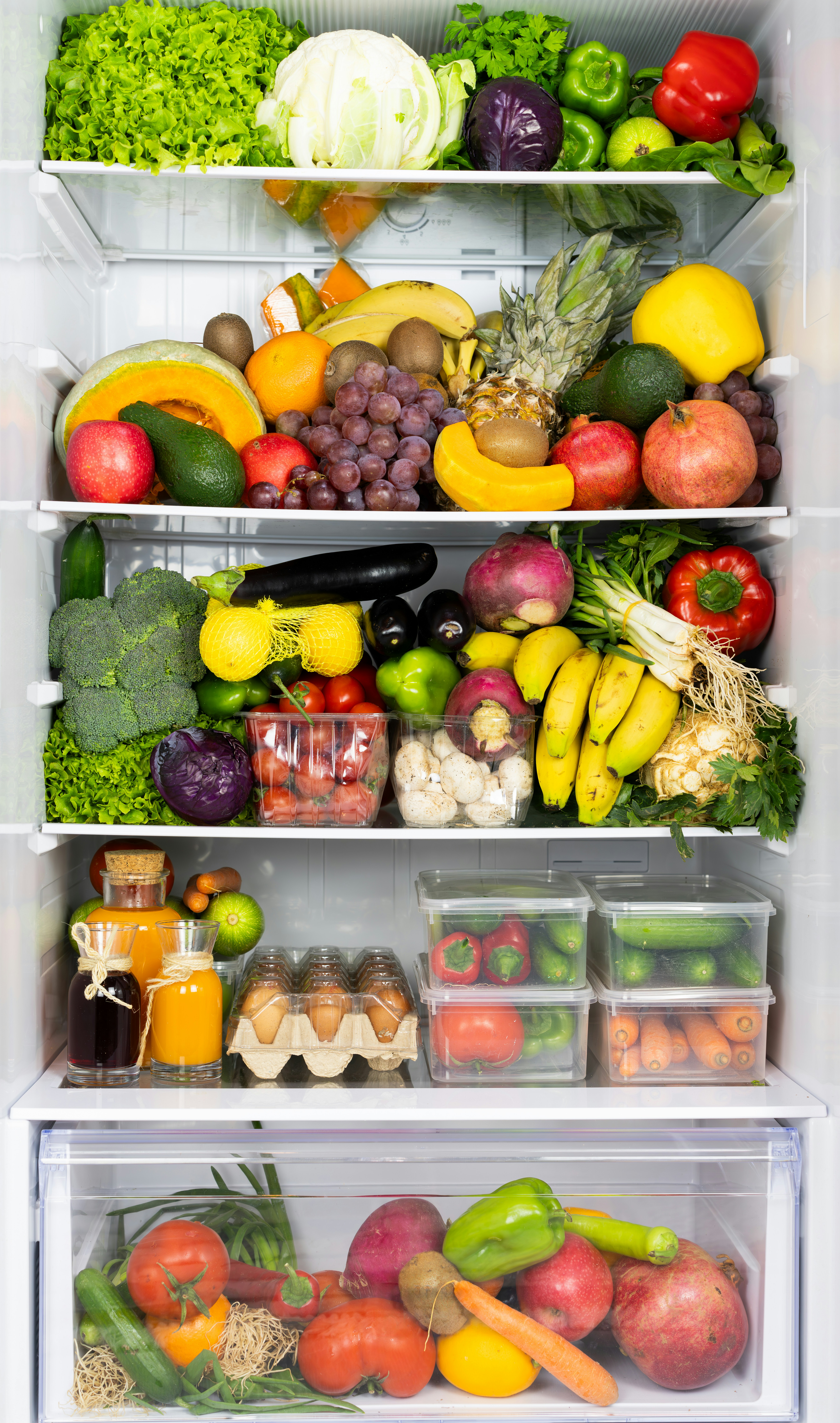 open fridge with healthy fruits, vegetables, and eggs