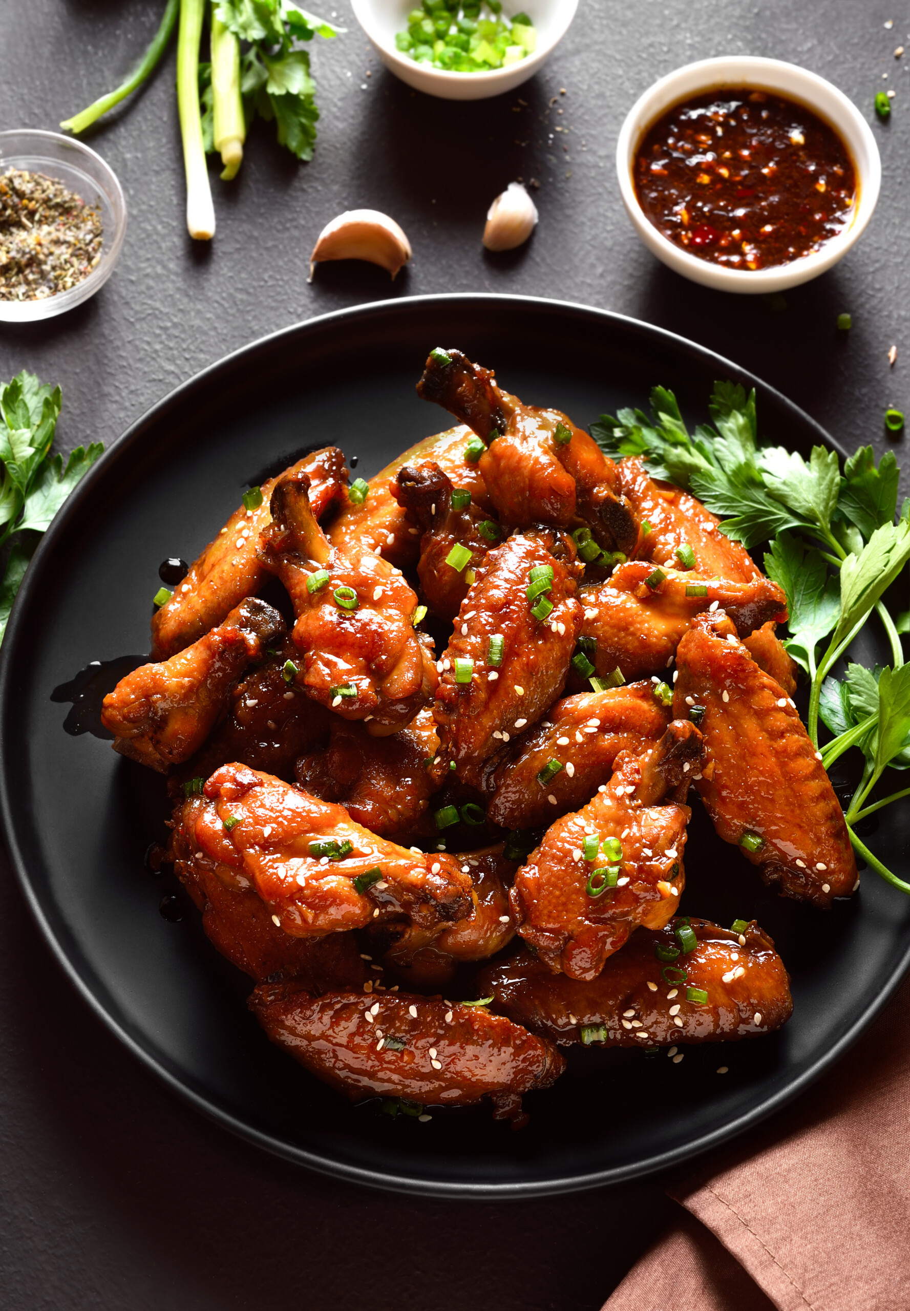 skillet of teriyaki wings and chili sauce on the sided