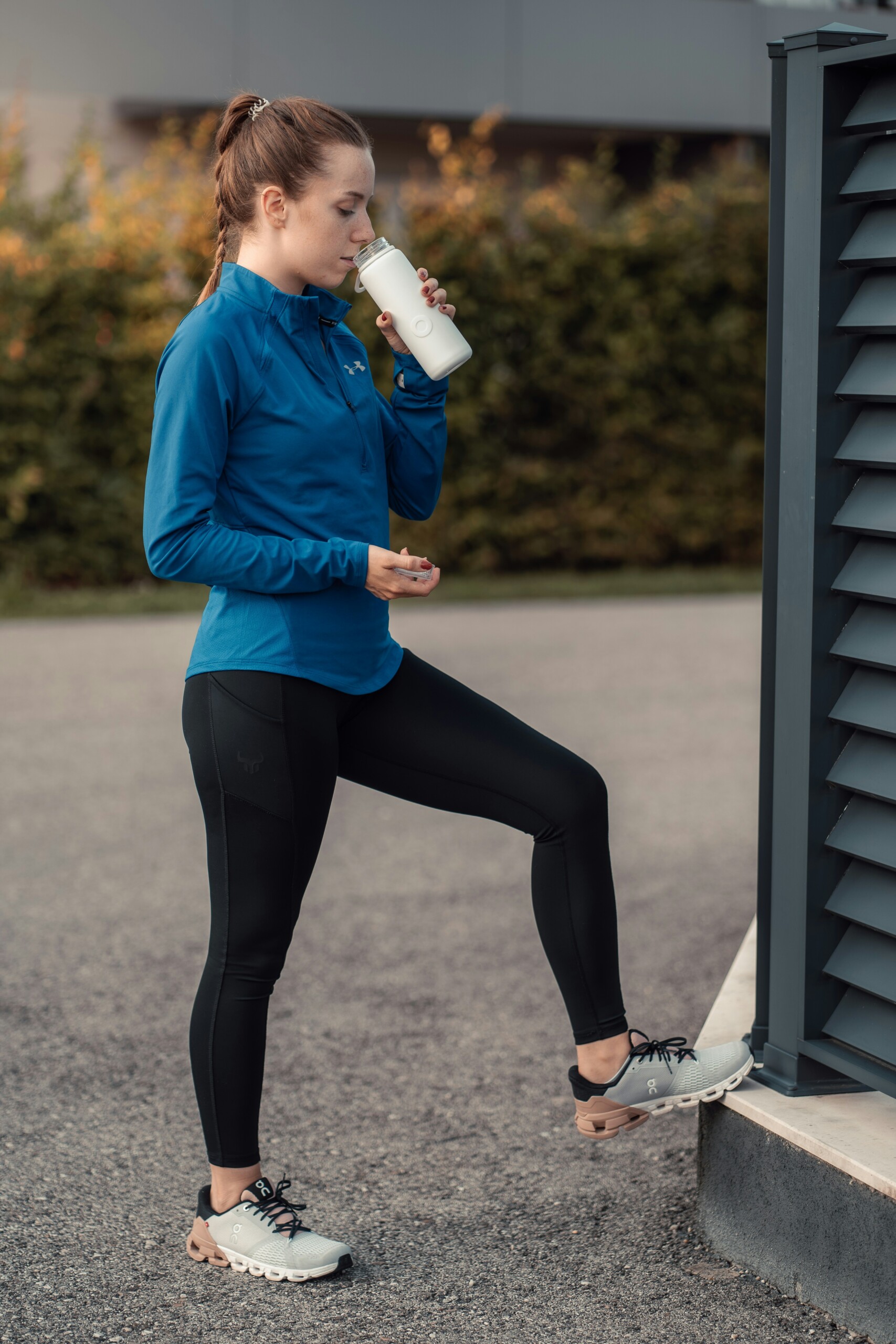 girl with leggings and running shoes with drink in white cup
